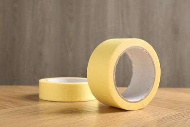 Two masking tapes on wooden table, closeup