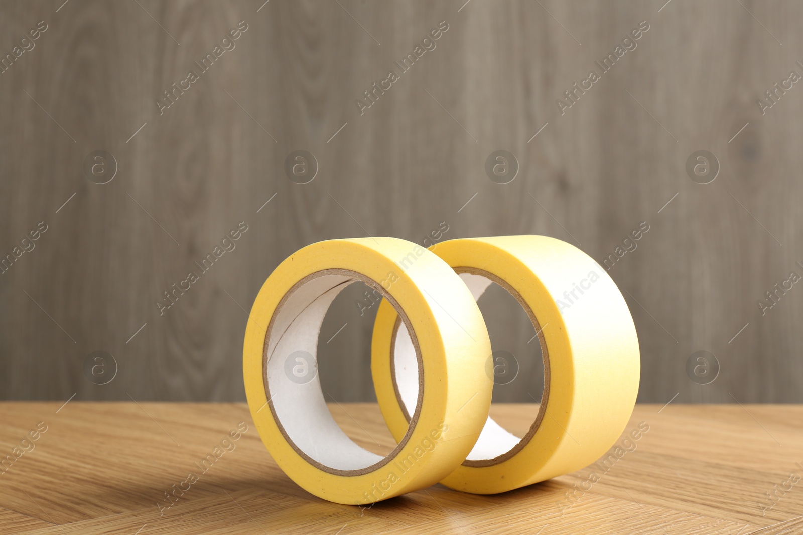 Photo of Two masking tapes on wooden table, closeup