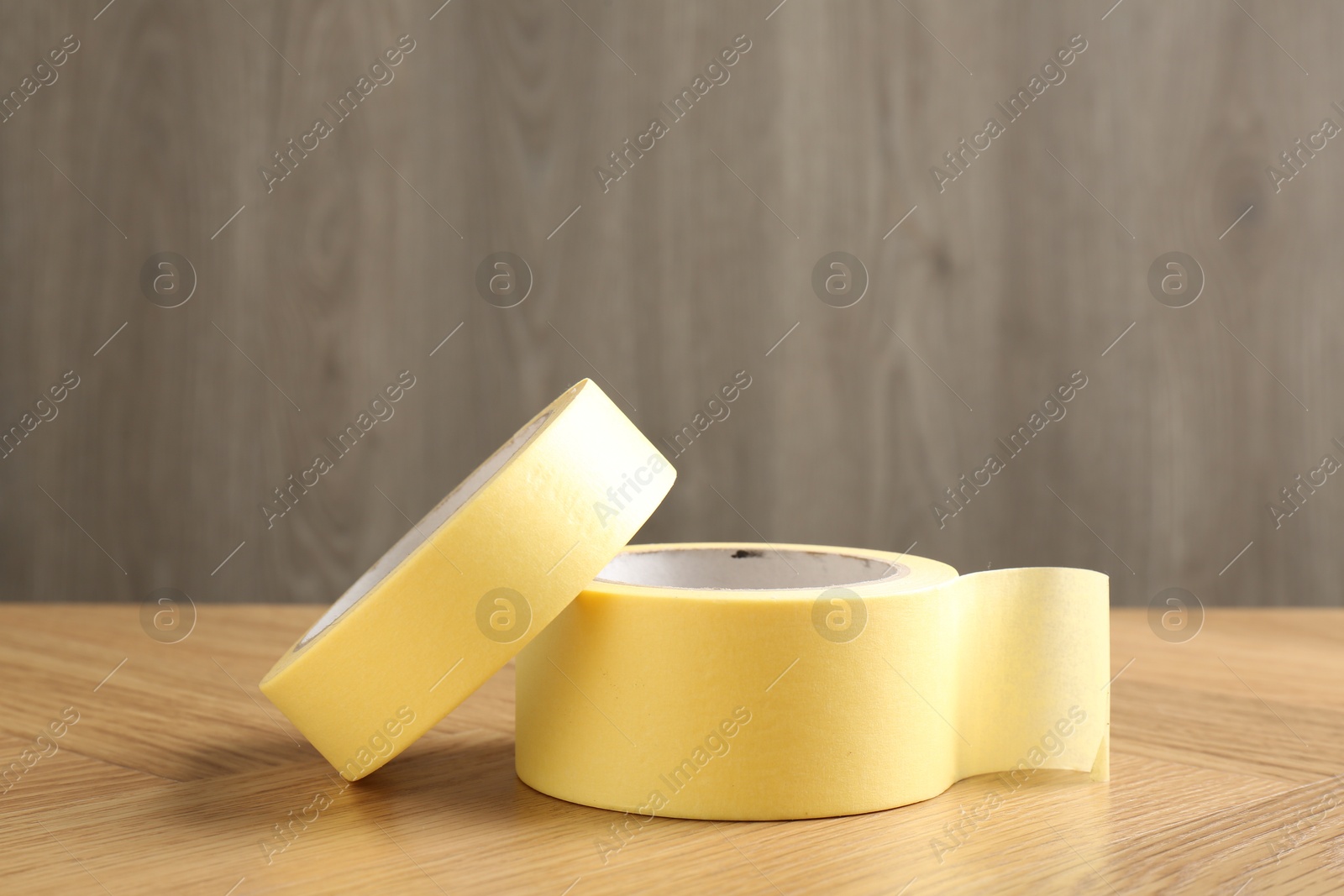 Photo of Two masking tapes on wooden table, closeup