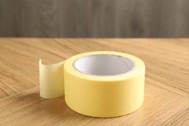 One adhesive tape on wooden table, closeup