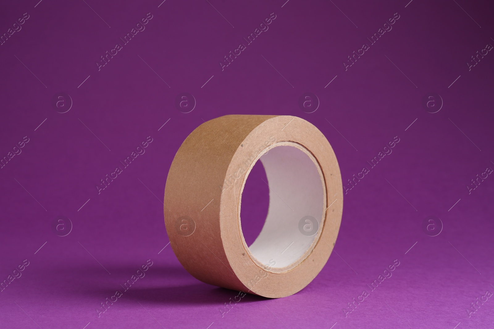 Photo of Roll of masking tape on violet background