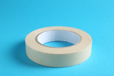 Photo of Roll of masking tape on light blue background