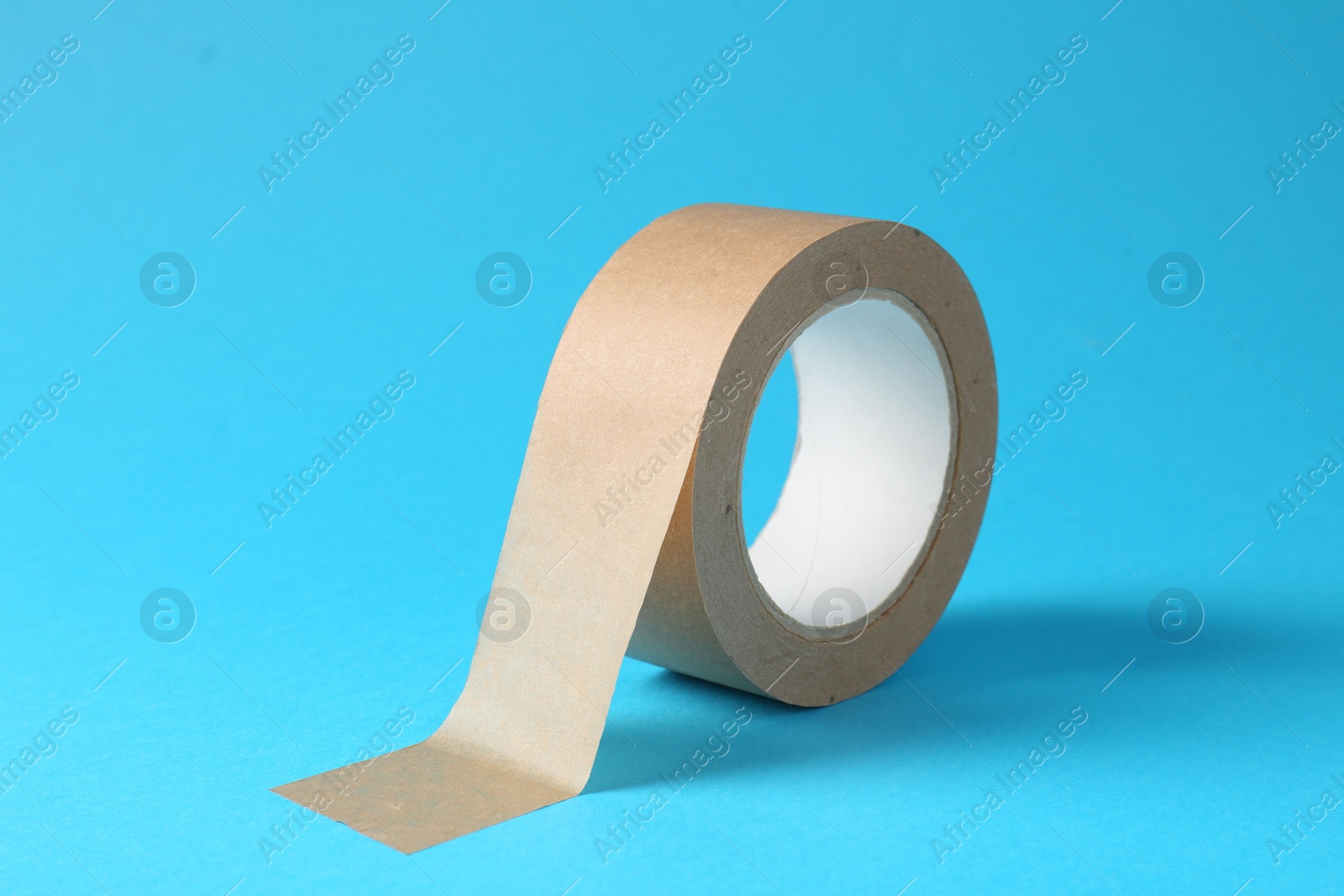 Photo of Roll of masking tape on light blue background