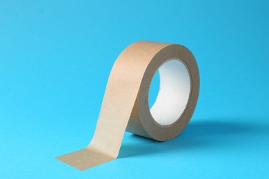 Photo of Roll of masking tape on light blue background