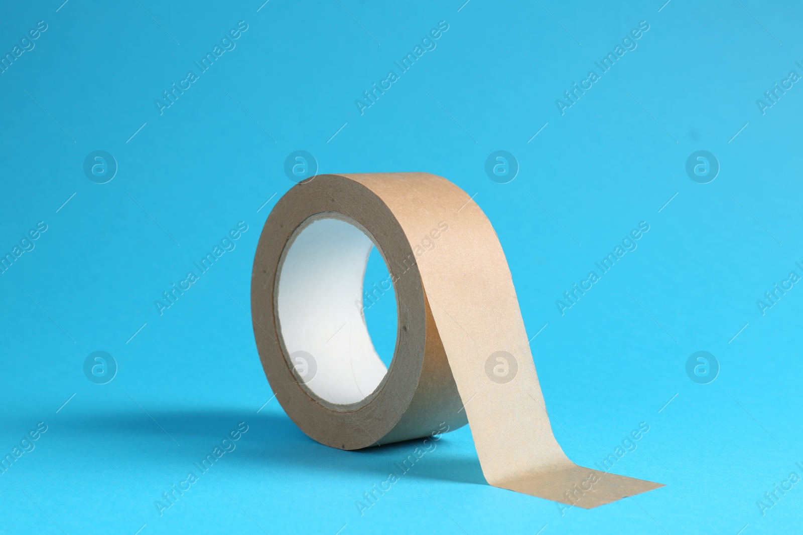 Photo of Roll of masking tape on light blue background