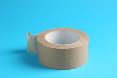 Photo of Roll of masking tape on light blue background