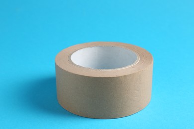 Photo of Roll of masking tape on light blue background