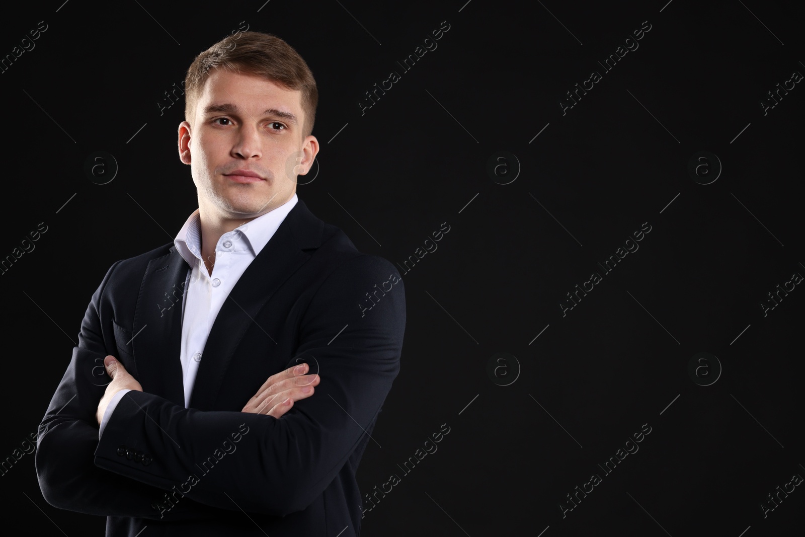 Photo of Man in classic suit on black background. Space for text