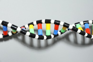 Photo of DNA structure model on light grey background, top view