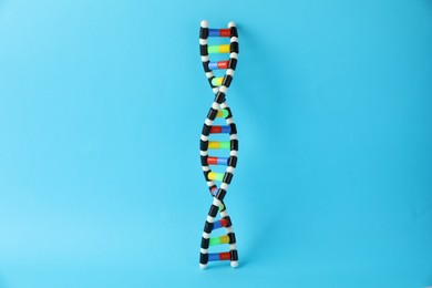 Photo of DNA structure model on light blue background