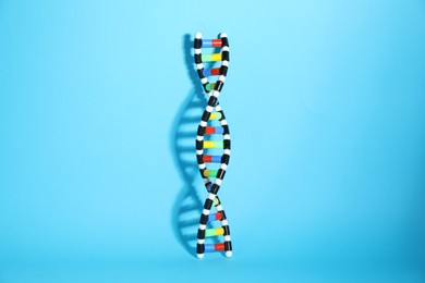 Photo of DNA structure model on light blue background