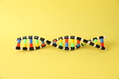 Photo of One DNA structure model on yellow background