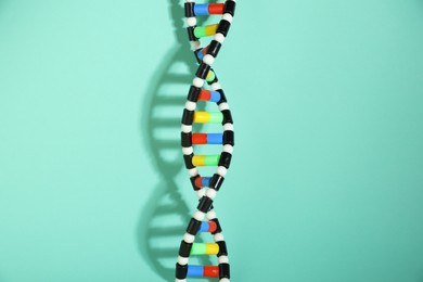 Photo of One DNA structure model on turquoise background