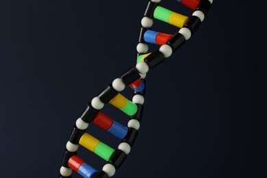 Photo of DNA structure model on dark background, closeup