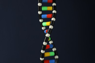 Photo of DNA structure model on dark background, closeup