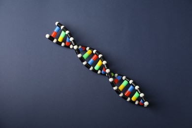 Photo of Colorful DNA structure model on dark blue background, top view