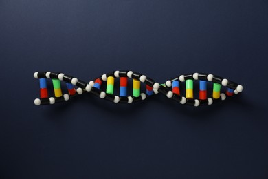 Photo of Colorful DNA structure model on dark blue background, top view