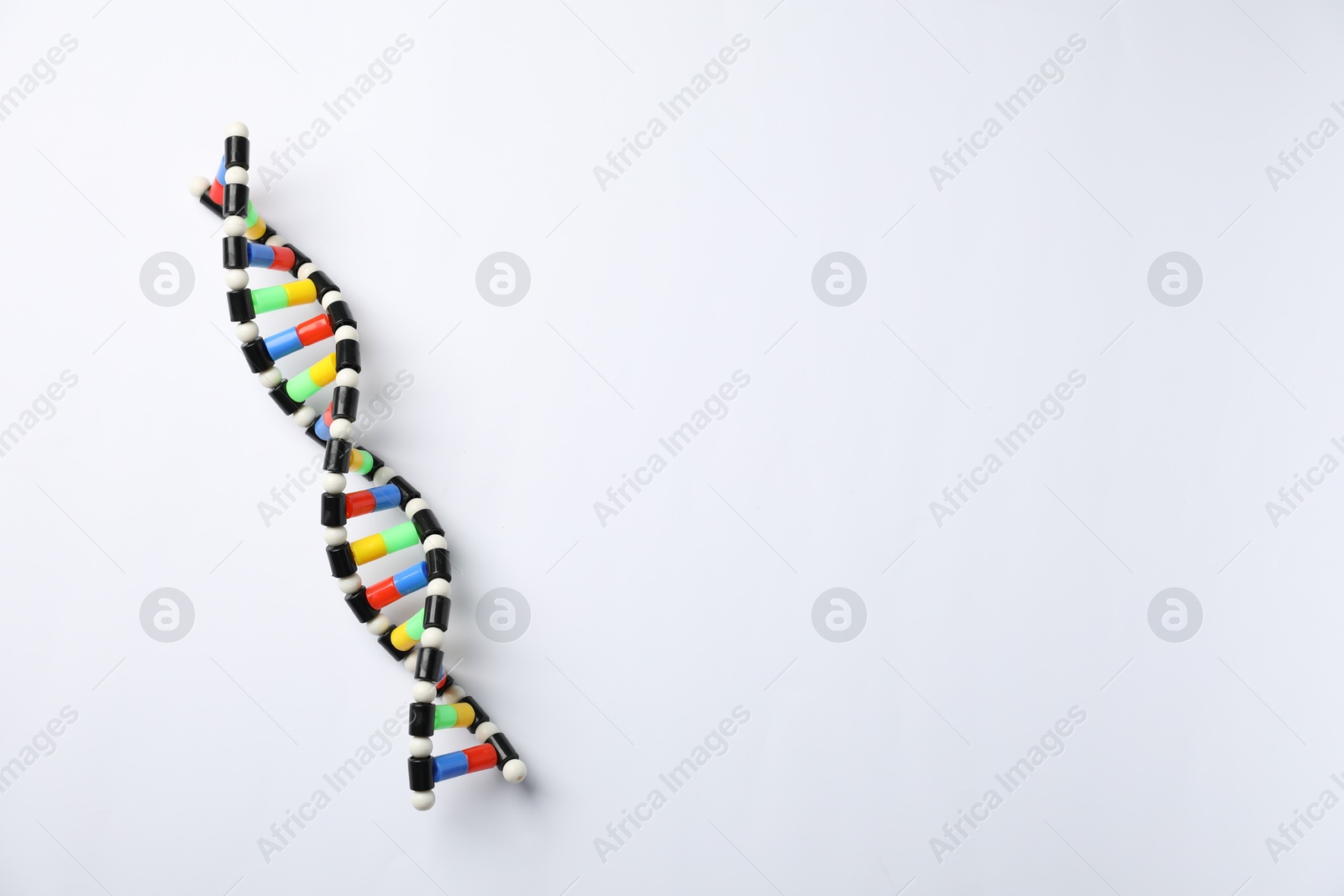 Photo of Colorful DNA structure model on white background, top view. Space for text