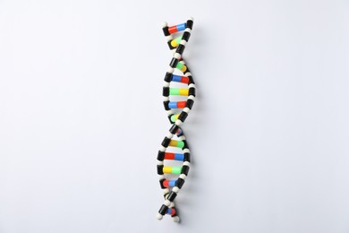 Photo of Colorful DNA structure model on white background, top view