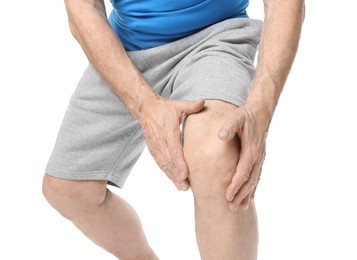 Senior man suffering from knee pain on white background, closeup