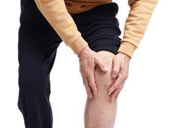 Senior man suffering from knee pain on white background, closeup