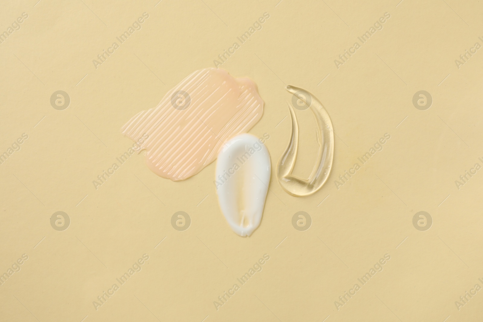 Photo of Samples of different cosmetic products on beige background, flat lay