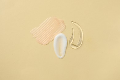 Photo of Samples of different cosmetic products on beige background, flat lay