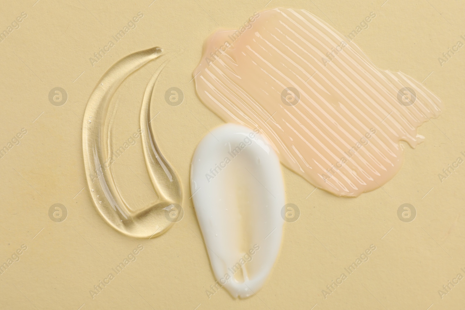 Photo of Samples of different cosmetic products on beige background, flat lay