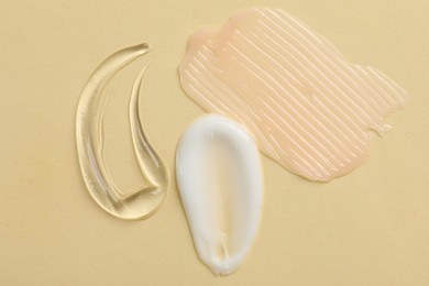 Photo of Samples of different cosmetic products on beige background, flat lay