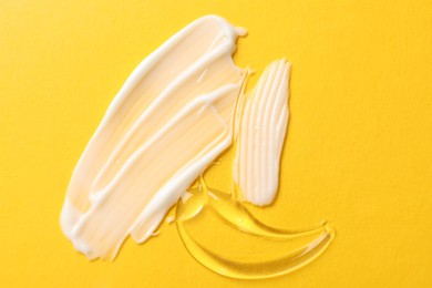 Photo of Samples of different cosmetic products on yellow background, flat lay