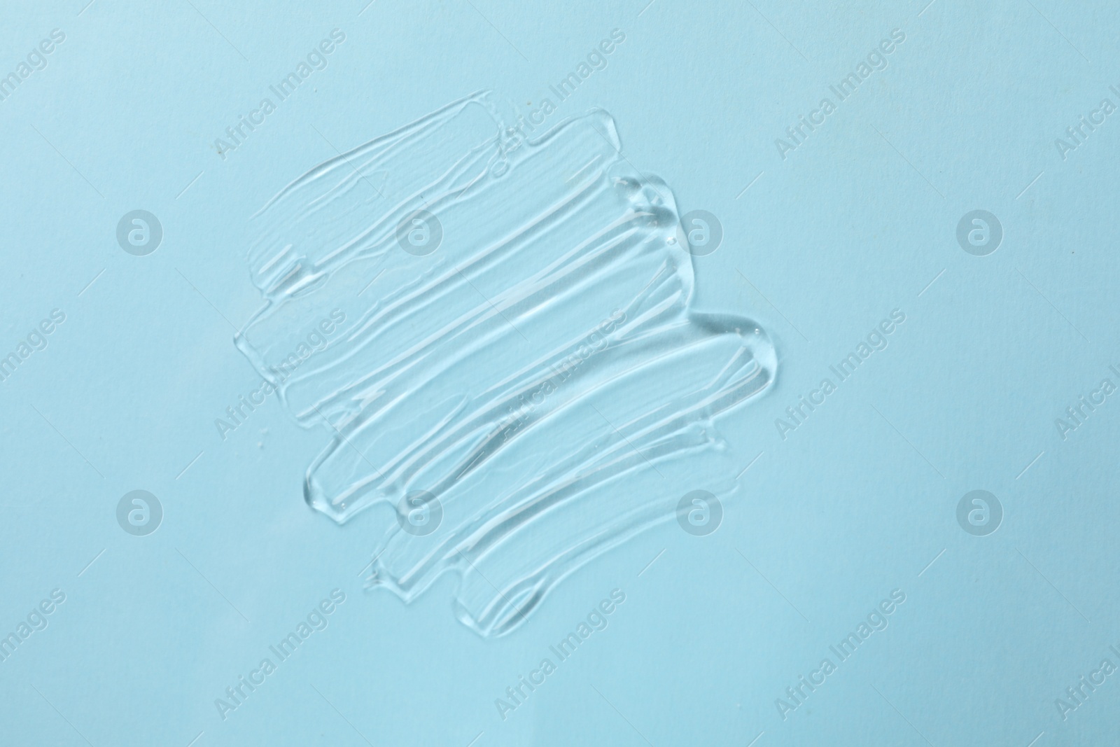 Photo of Sample of cosmetic product on light blue background, top view