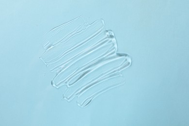 Photo of Sample of cosmetic product on light blue background, top view