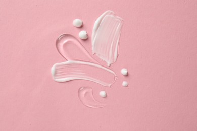 Photo of Samples of different cosmetic products on pink background, flat lay