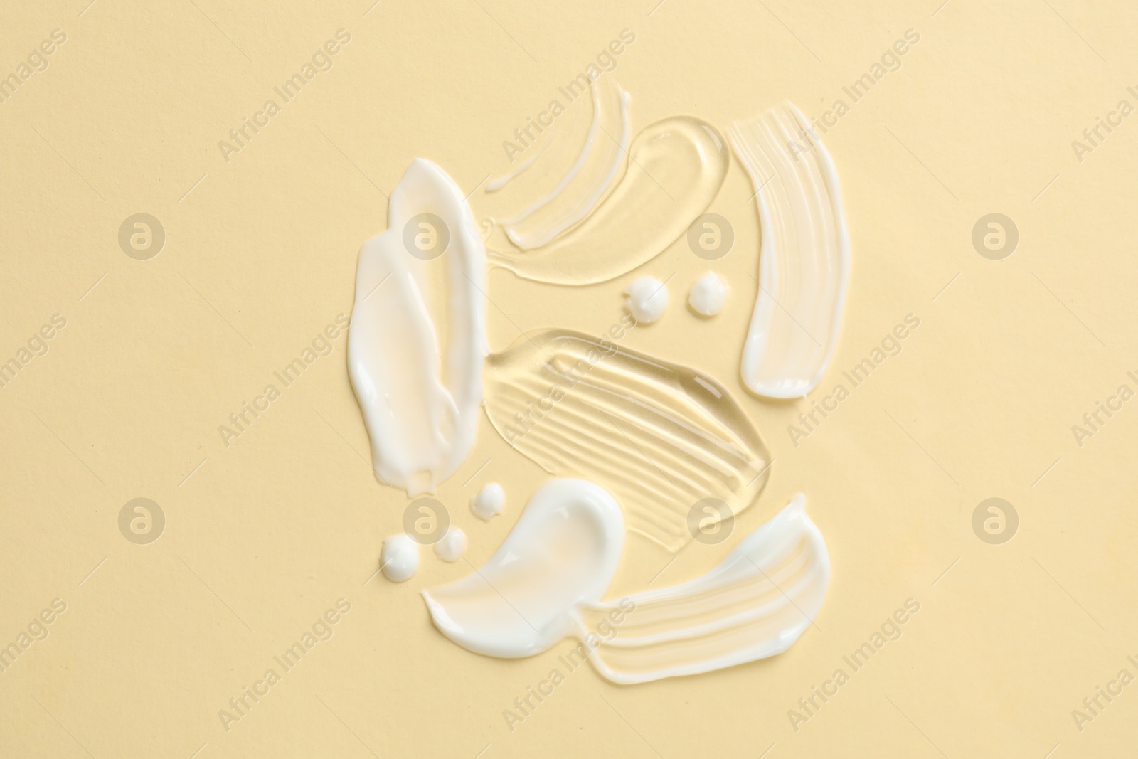 Photo of Samples of different cosmetic products on beige background, flat lay