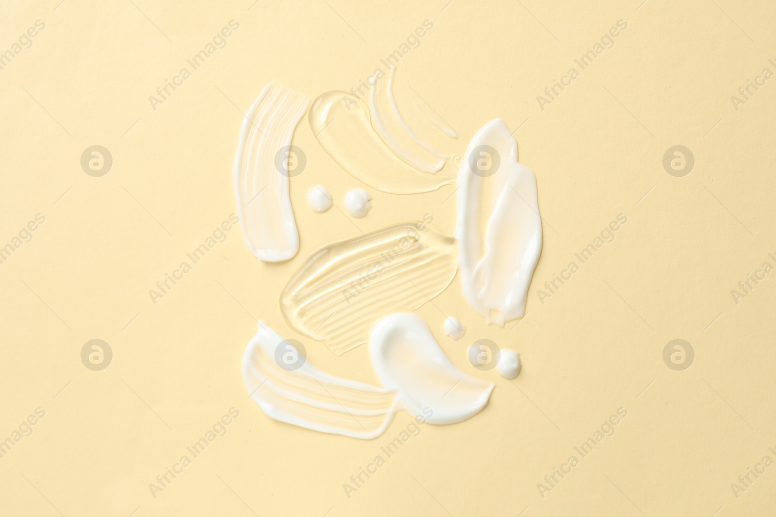 Photo of Samples of different cosmetic products on beige background, flat lay