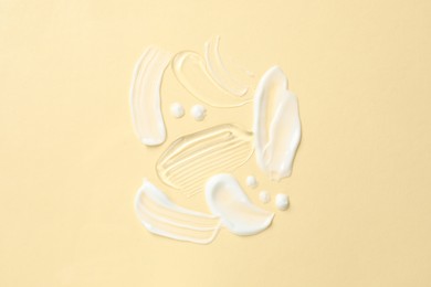 Photo of Samples of different cosmetic products on beige background, flat lay