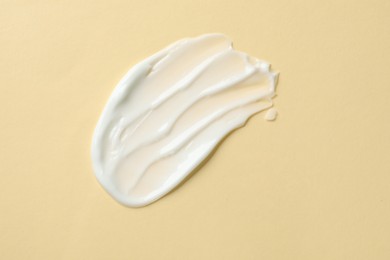 Photo of Sample of body cream on beige background, top view