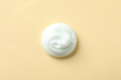 Photo of Sample of body cream on beige background, top view