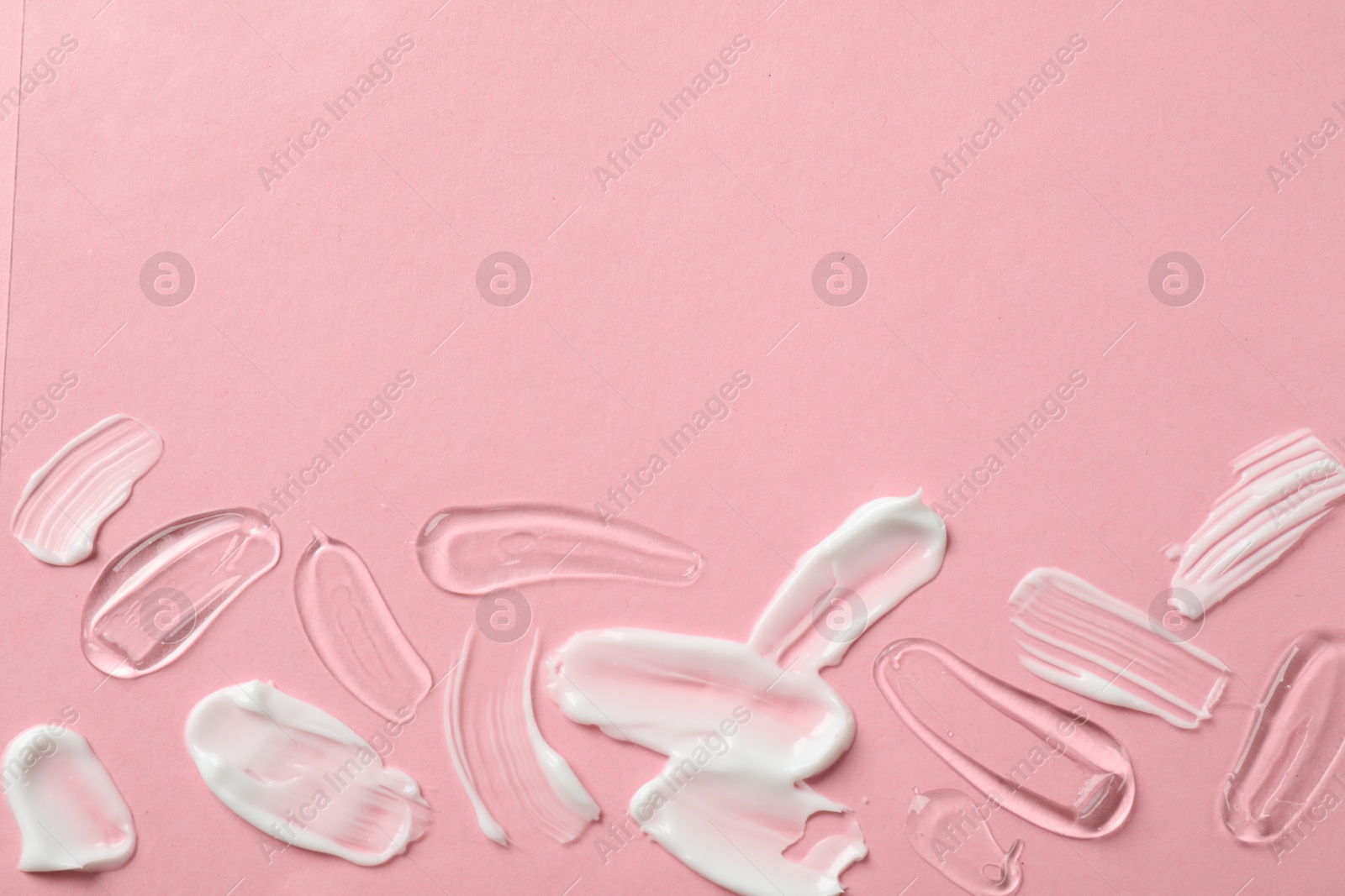 Photo of Samples of different cosmetic products on pink background, flat lay. Space for text