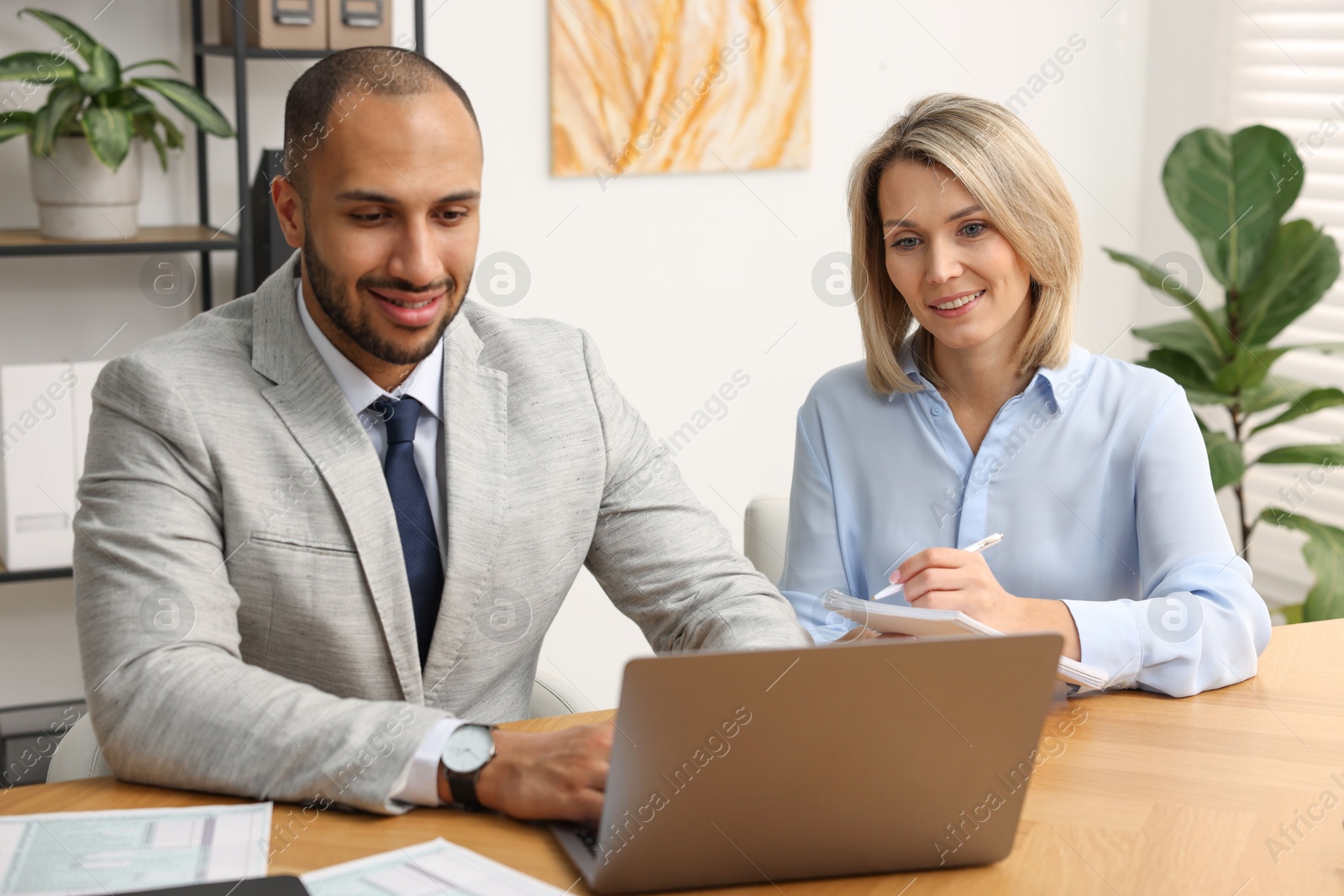 Photo of Coworkers with laptop working together in office