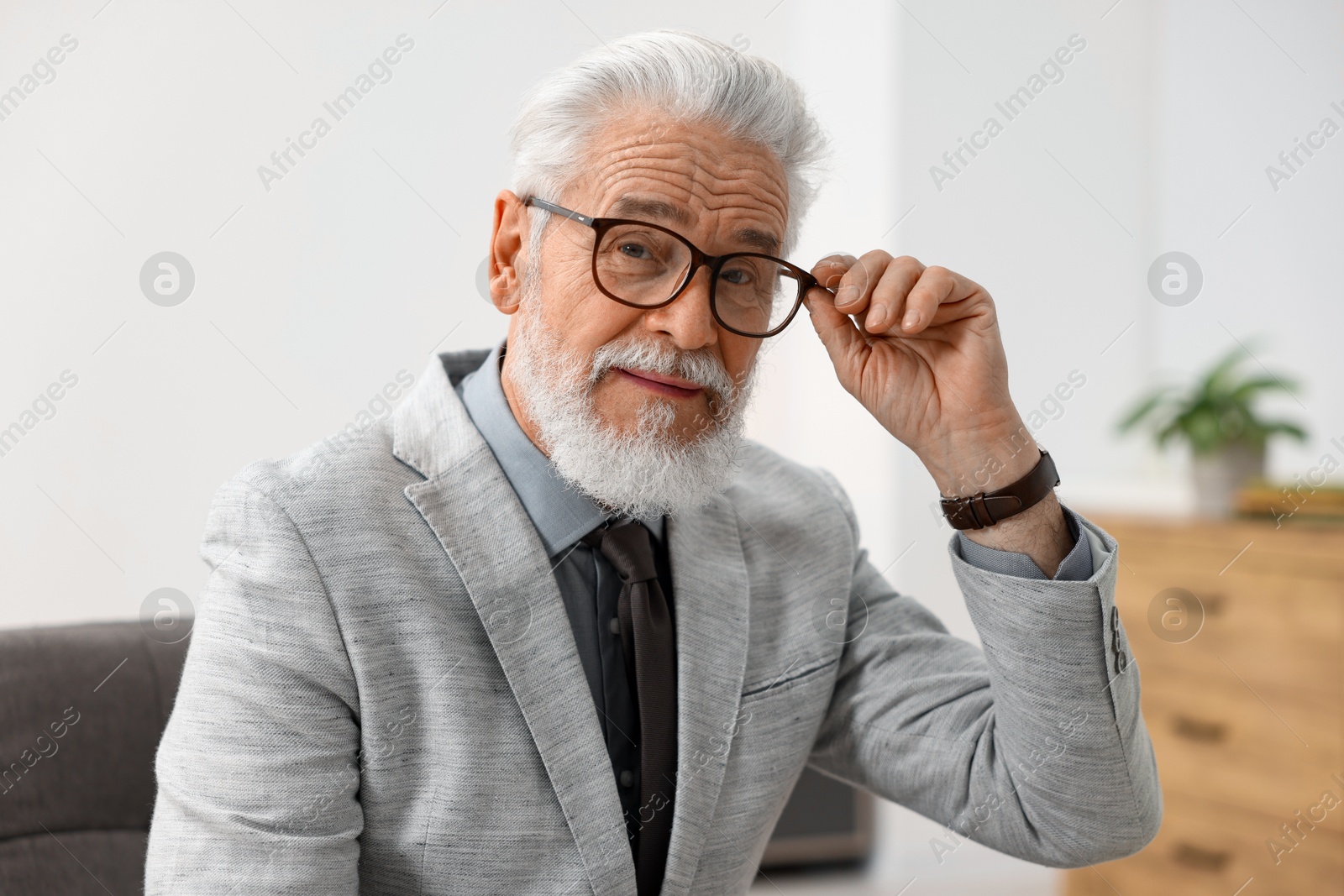 Photo of Portrait of handsome bearded man in armchair indoors