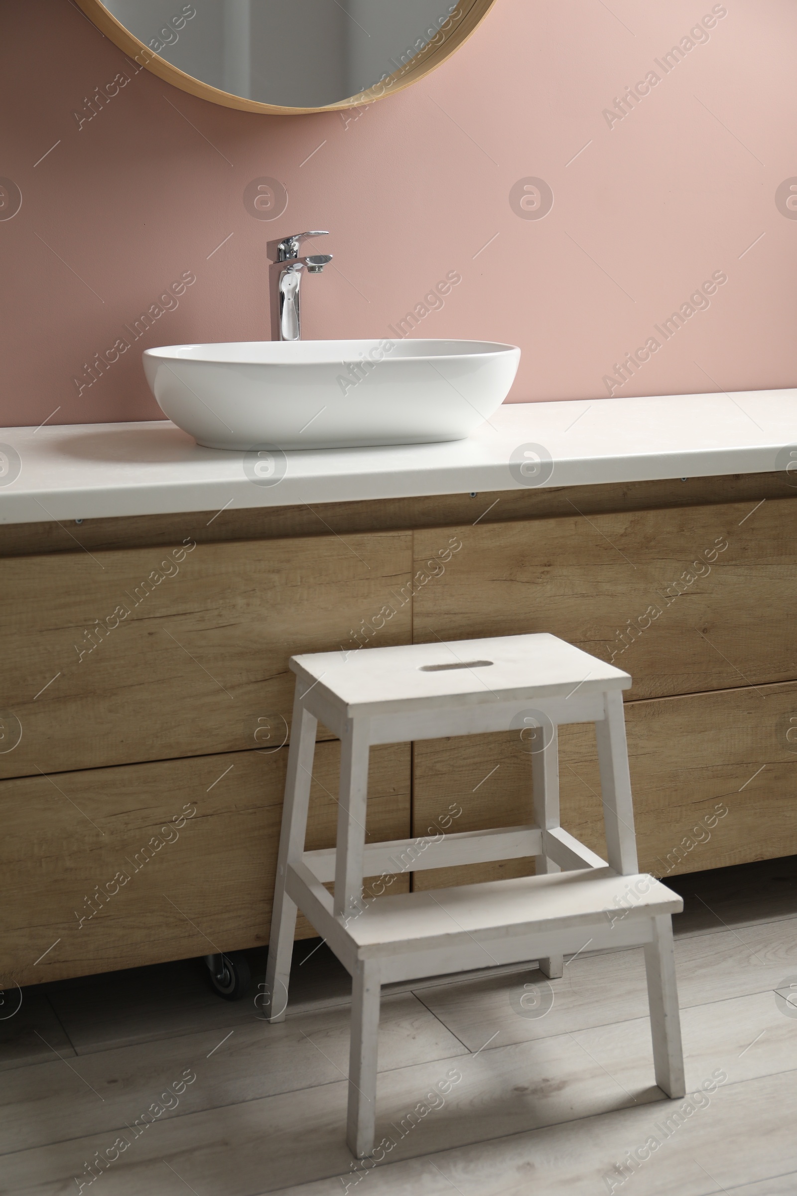 Photo of Wooden step stool near bathroom vanity indoors