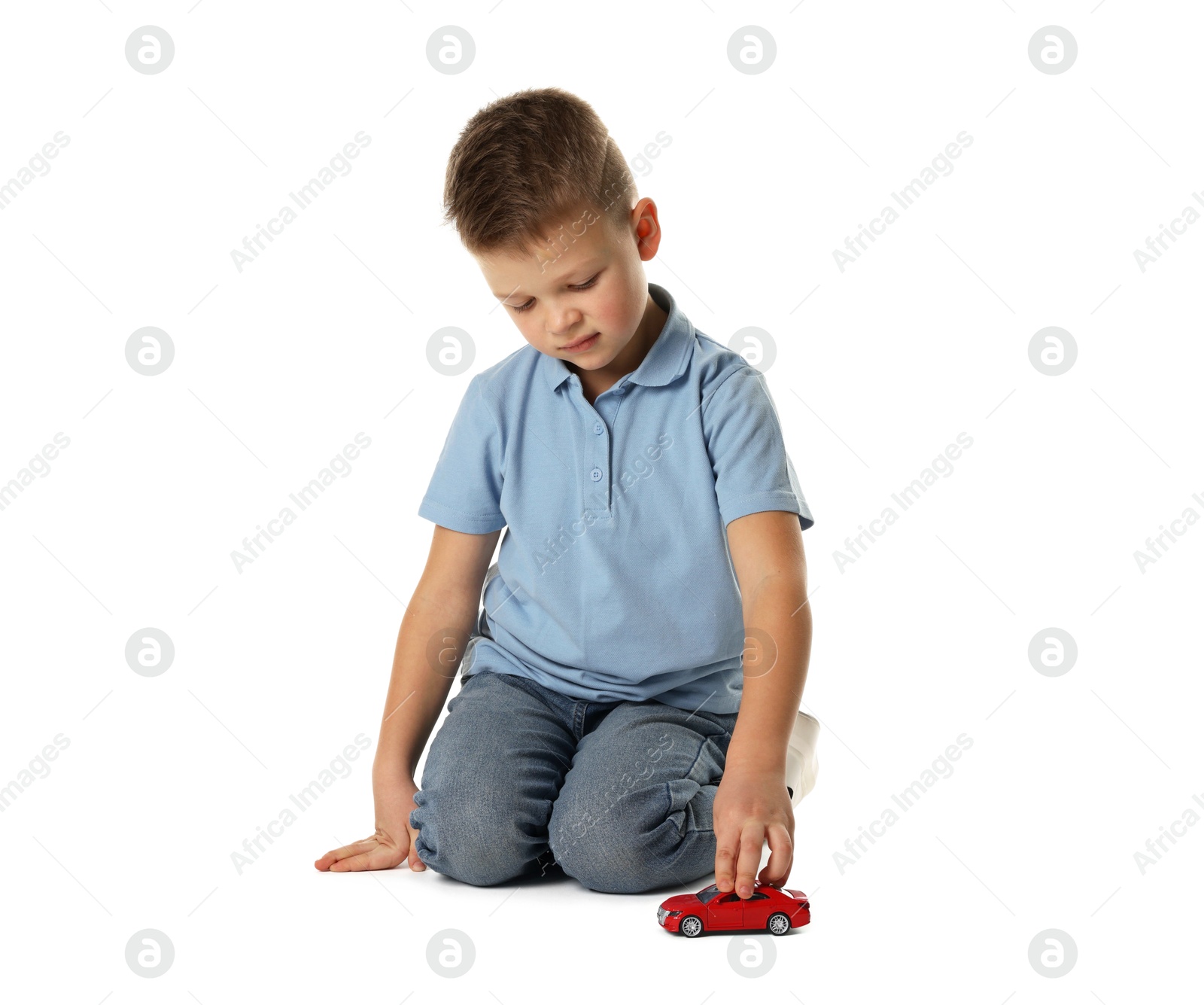 Photo of Little boy playing with toy car on white background