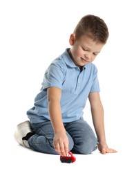 Photo of Little boy playing with toy car on white background