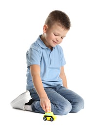 Little boy playing with toy car on white background