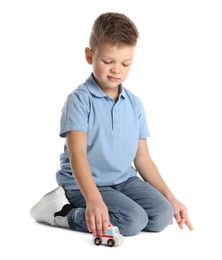 Little boy playing with toy car on white background