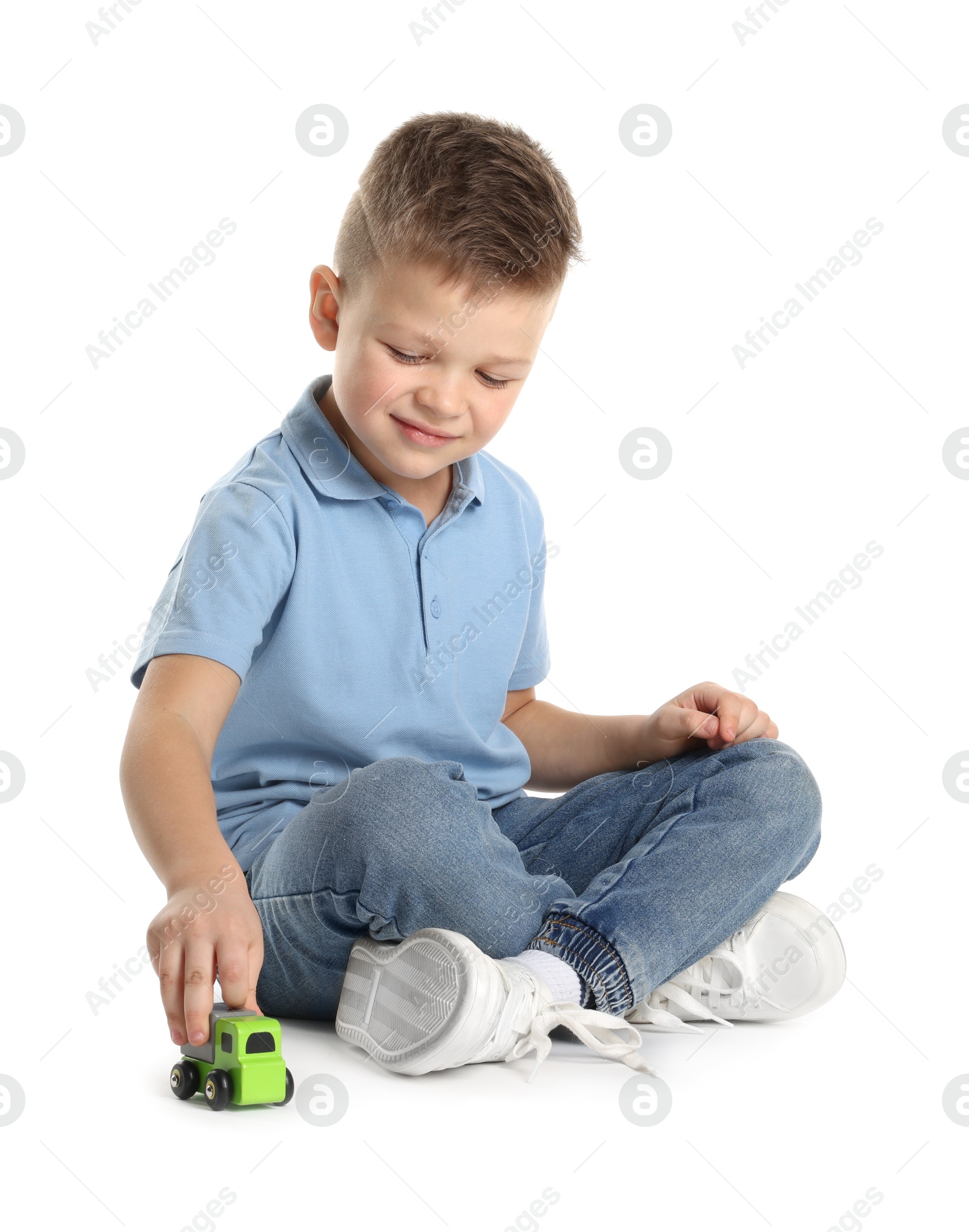 Photo of Little boy playing with toy car on white background