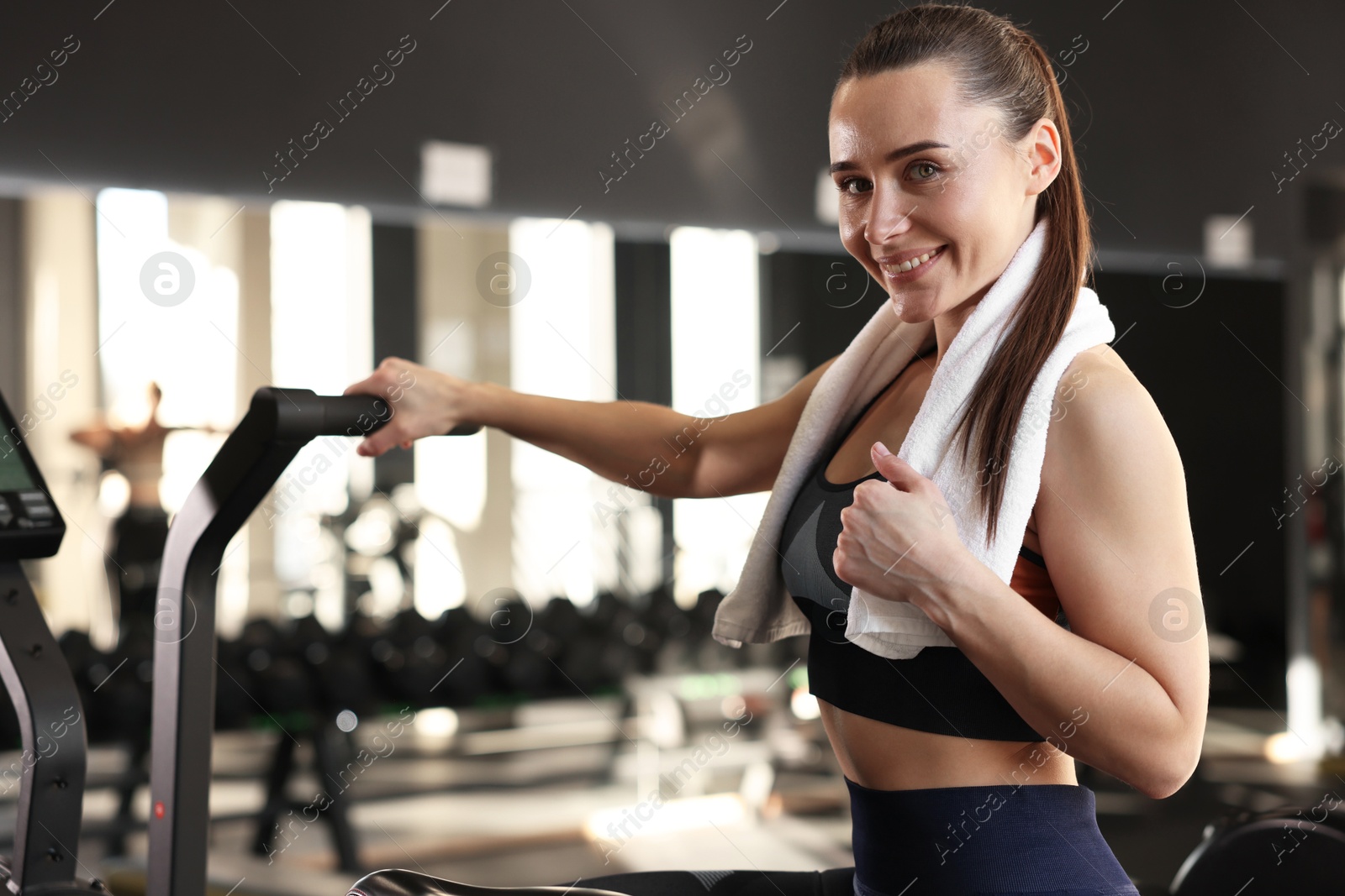 Photo of Happy woman with terry towel in gym