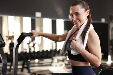 Happy woman with terry towel in gym