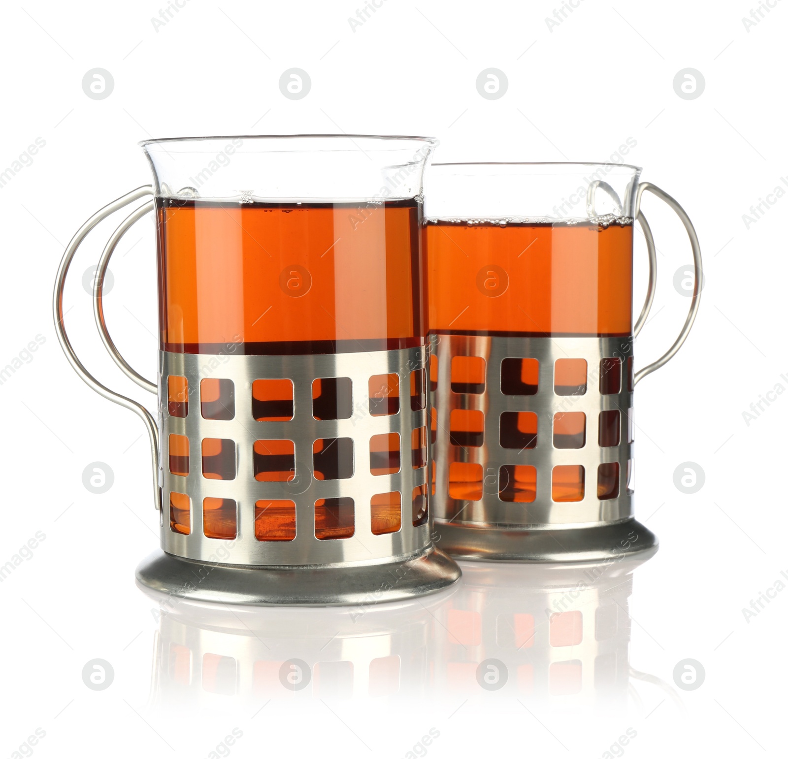 Photo of Glasses of aromatic tea in holders isolated on white